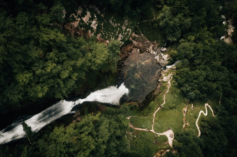 view of a waterfall from above surrounded by lush green trees