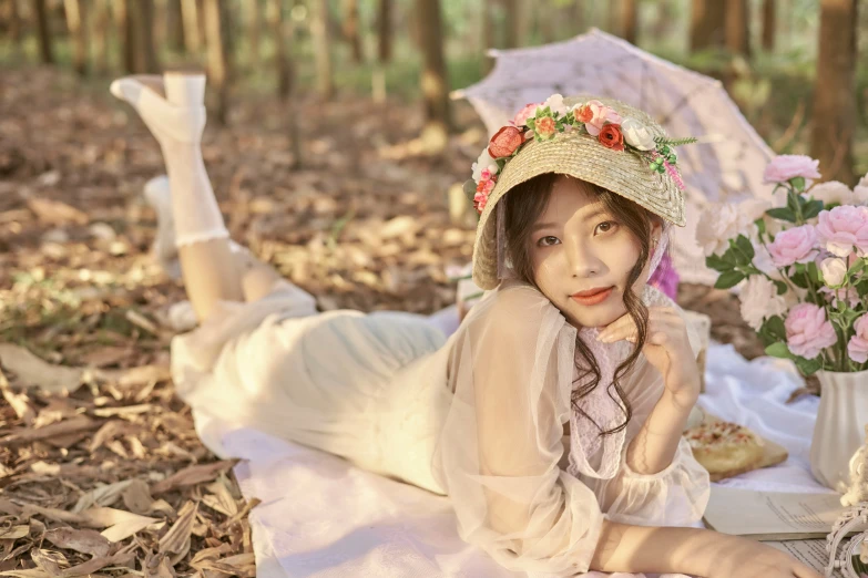 a woman wearing a floral hat and dress in the woods