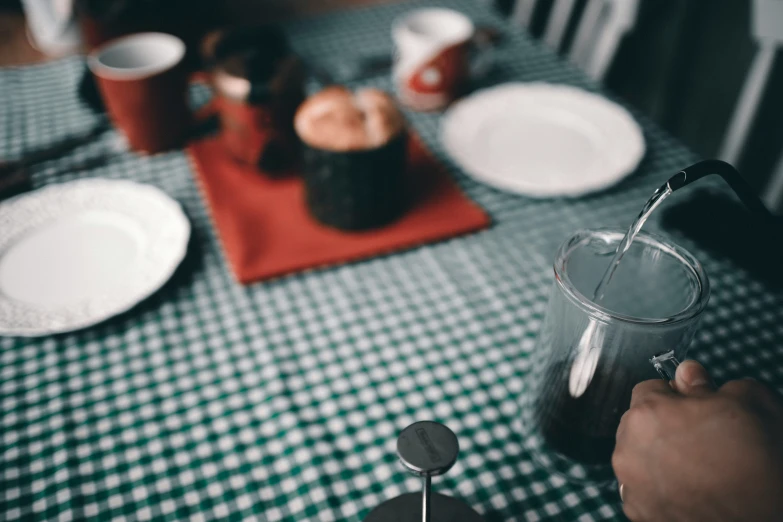 a person holding a spoon in their hand with liquid in the background