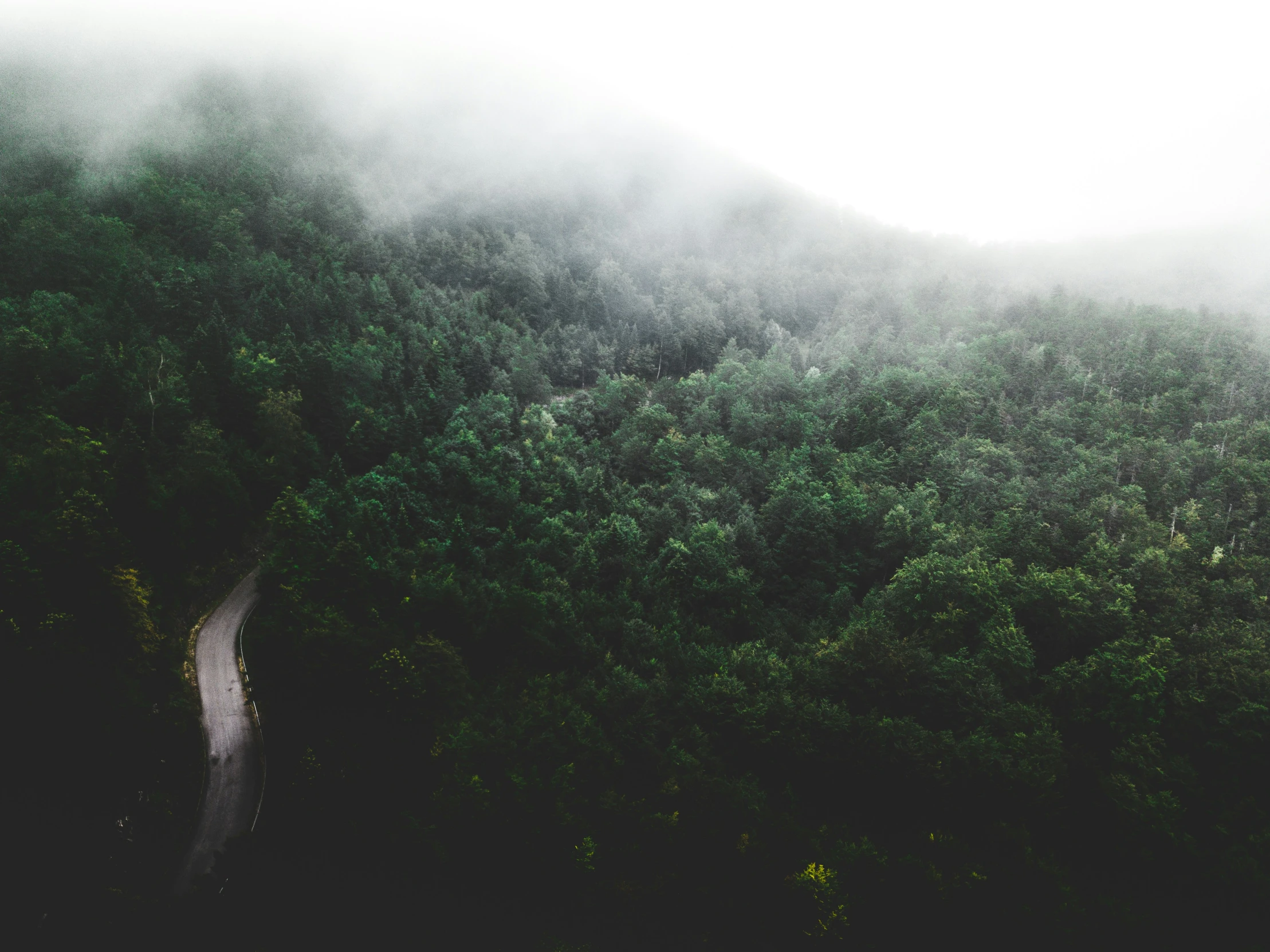 a po taken from the air looking down at foggy mountains