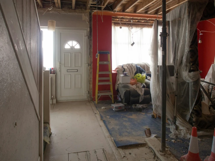 a house under construction with ladders in front of a doorway and the inside walls missing