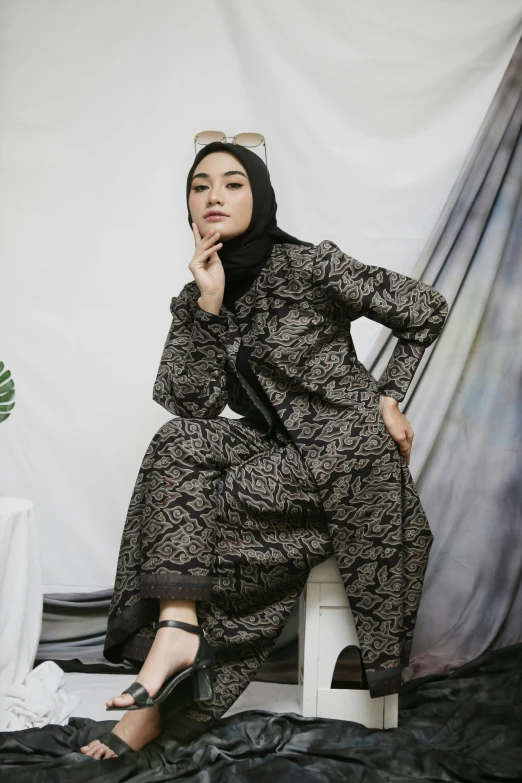 woman wearing abaah dress sitting in front of the studio curtain