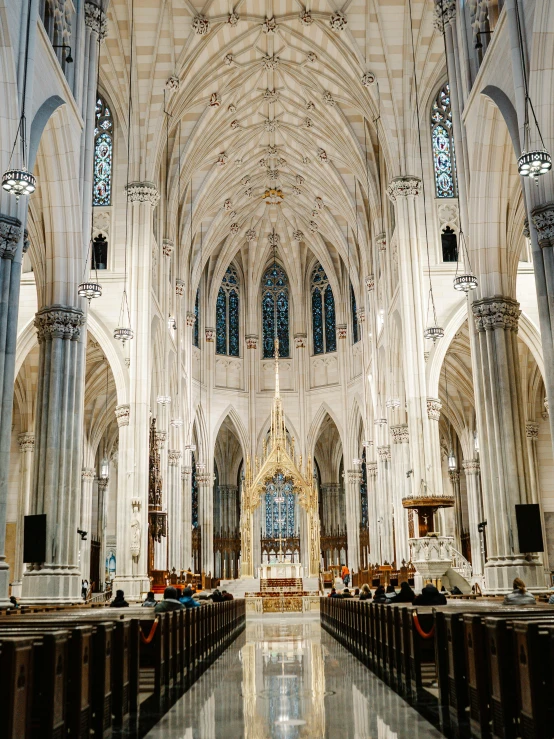 a long cathedral with benches and stained glass windows