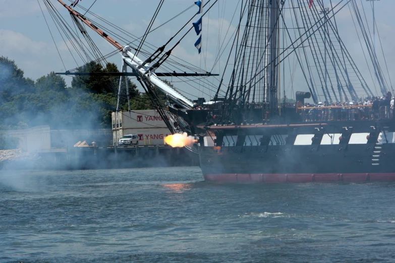 a large sailboat with smoke rising out of the deck