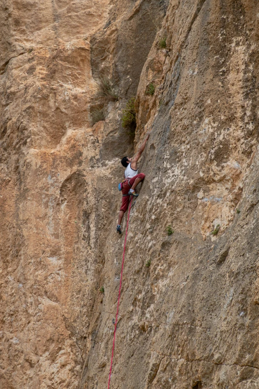 a man climbing a tall cliff while trying to climb