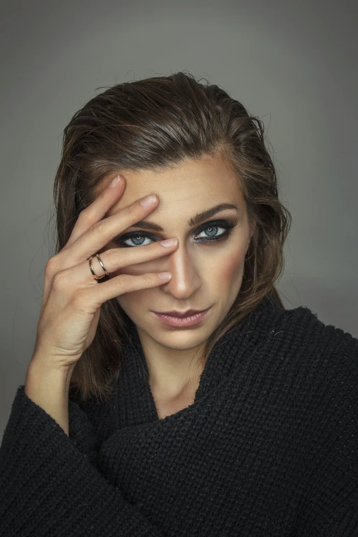 the woman is posing for the camera with her hand on her head