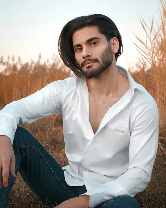 a young man wearing a white shirt and blue jeans
