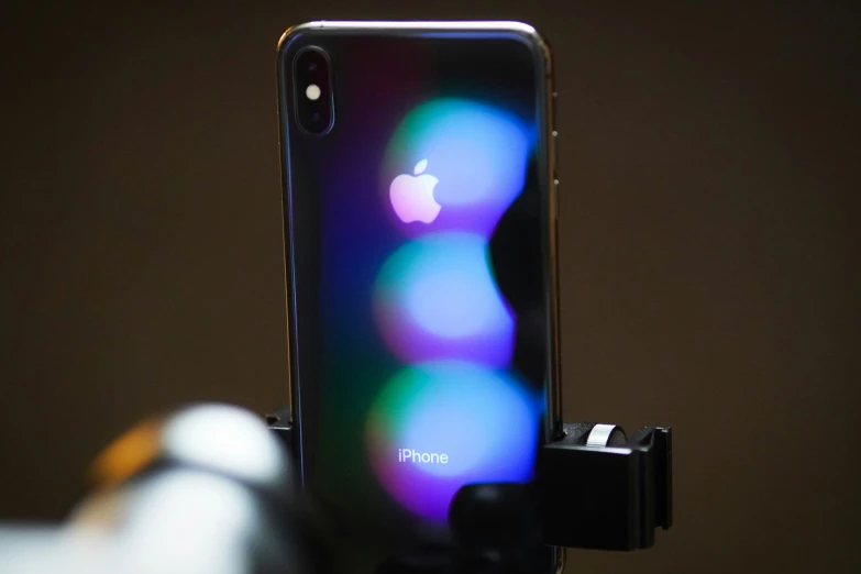 an iphone sitting in the holder on top of a table