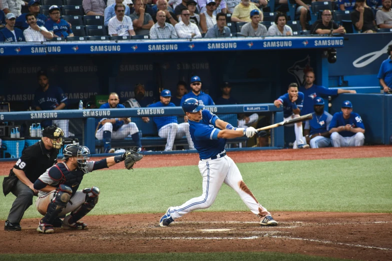 a baseball player hitting the ball while standing next to home plate
