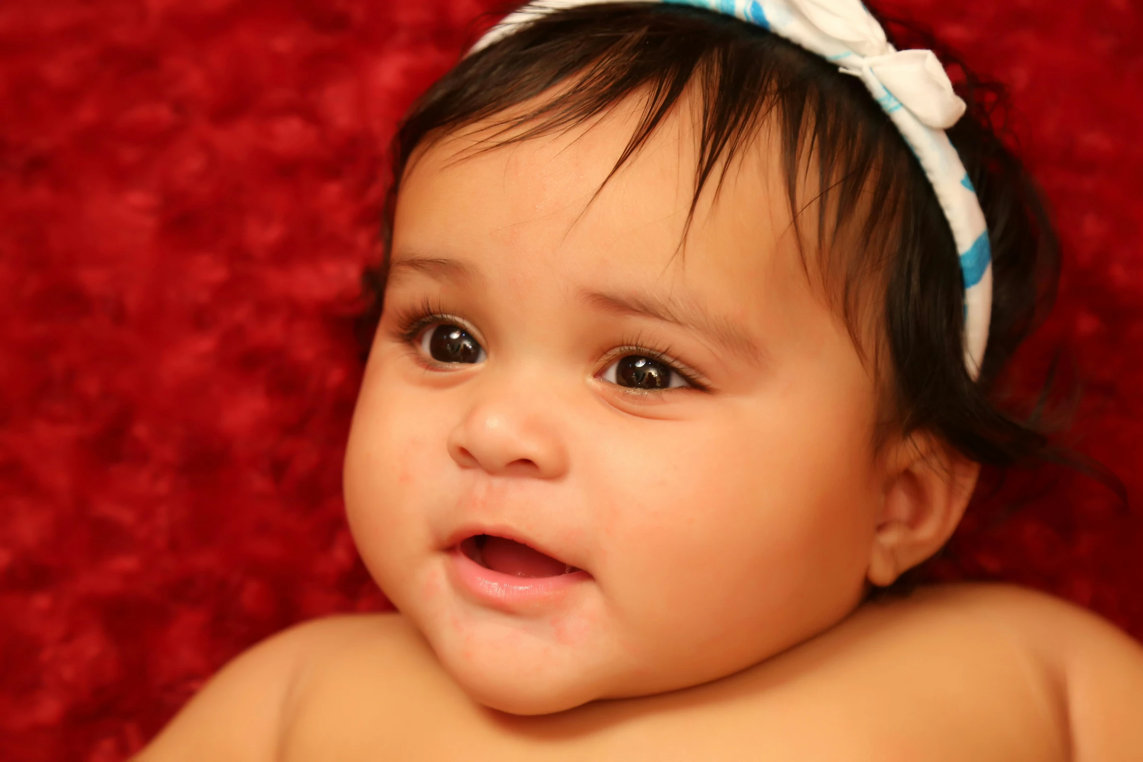 a cute young baby wearing a blue and white bow tie on her head