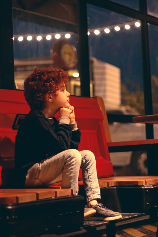 a small child sitting by a window while eating