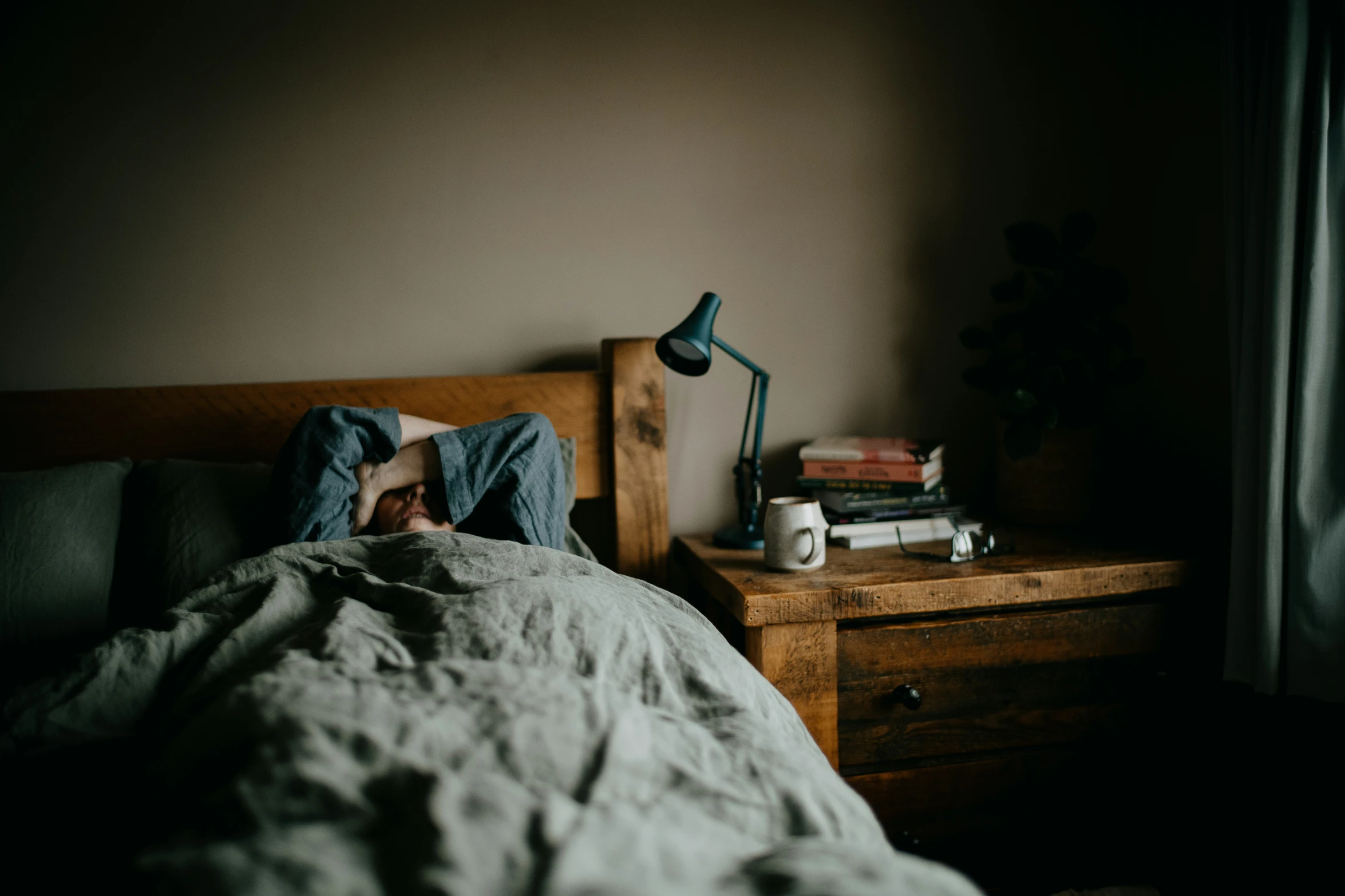 a person sleeping on a bed with an unmade sheet