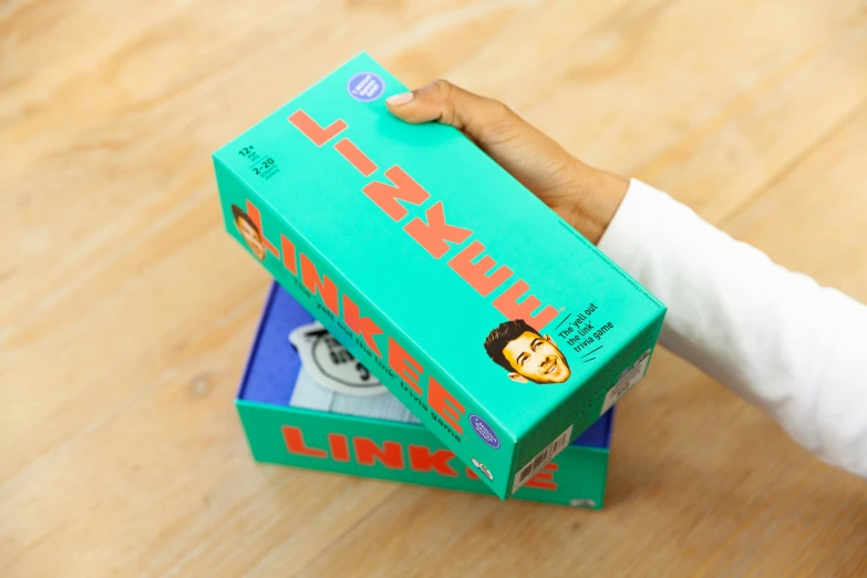 a child's hand holding a box of gummy pants