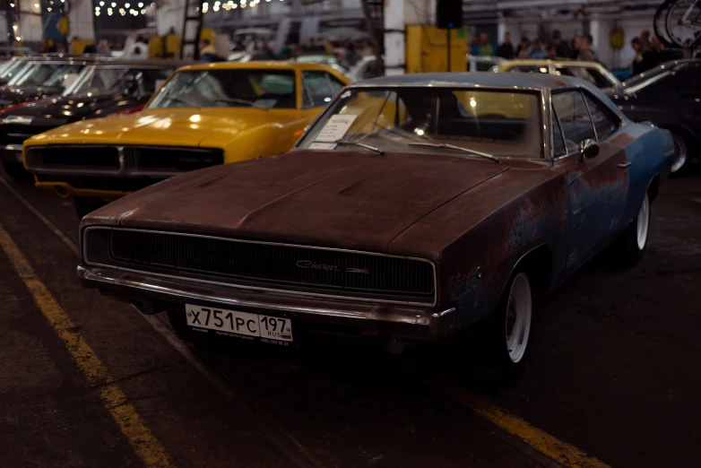 old cars are parked on the street while a crowd watches them