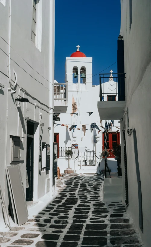 a narrow street with a church in the distance