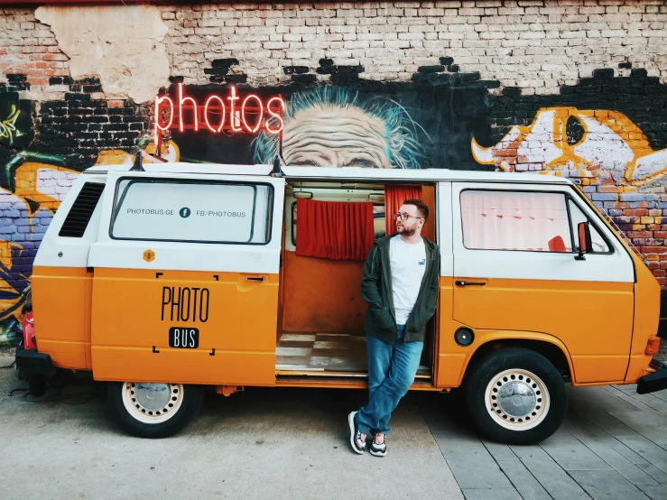 man standing in the door to an orange and white van