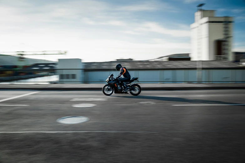 person on motorcycle traveling fast through empty urban street