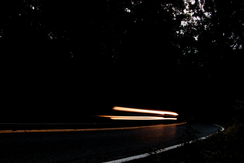 a long exposure pograph of cars traveling on a road at night