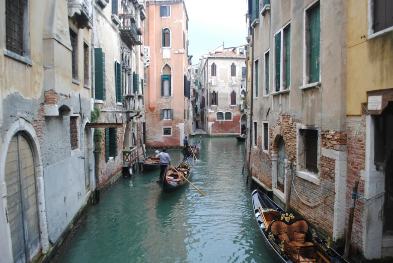 some boats are going down the narrow waterway