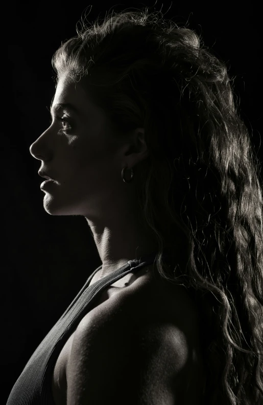 an attractive woman looking down with her hair blown back