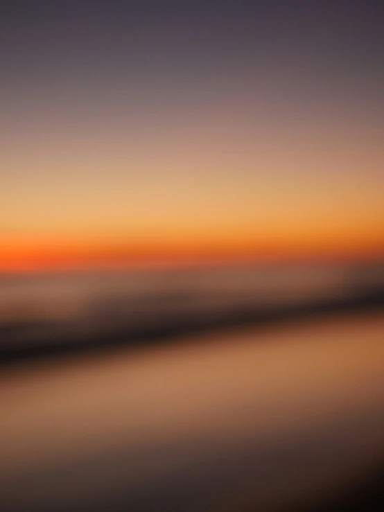 an airplane wing with a blurry view of the sunset