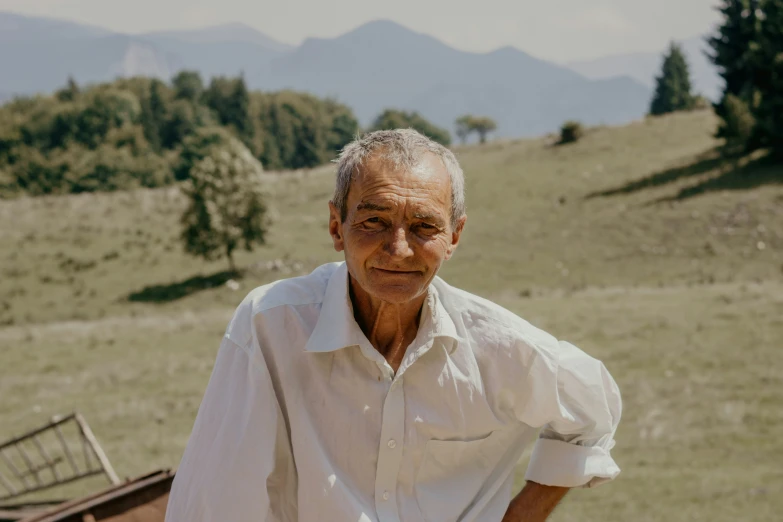 a man wearing white on top of a lush green hillside