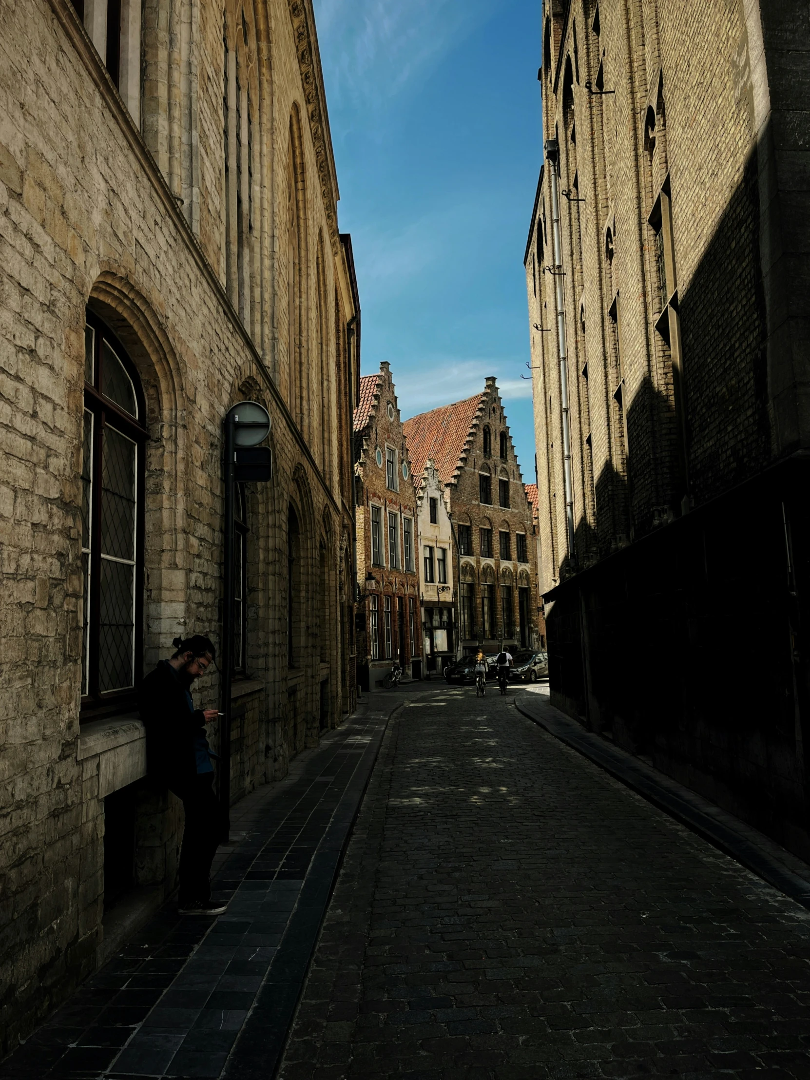 the narrow alley in old town has a man taking a po