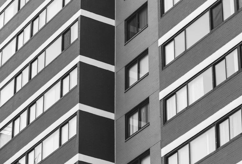 a gray and white image of windows on the side of an apartment building