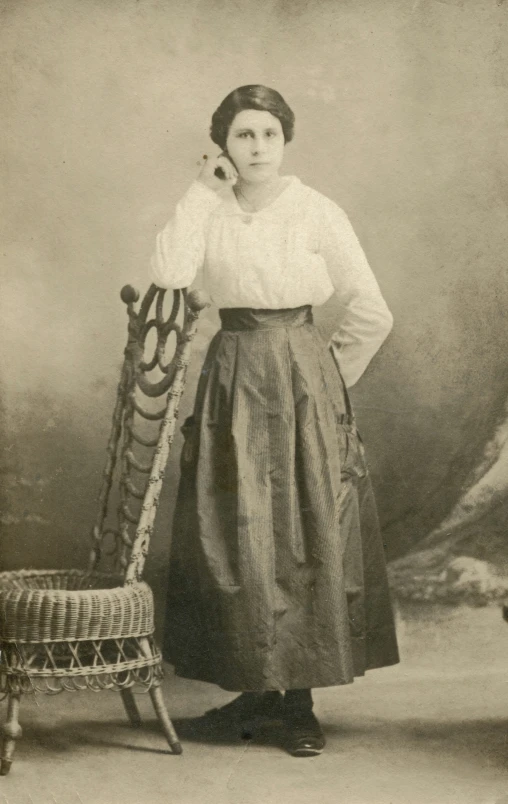 an old picture of a woman posing with a chair and rocking chair