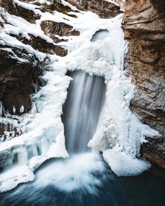 a waterfall with ice formations flowing out of it