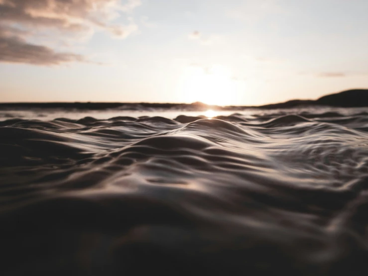 some dark water with the sun setting behind