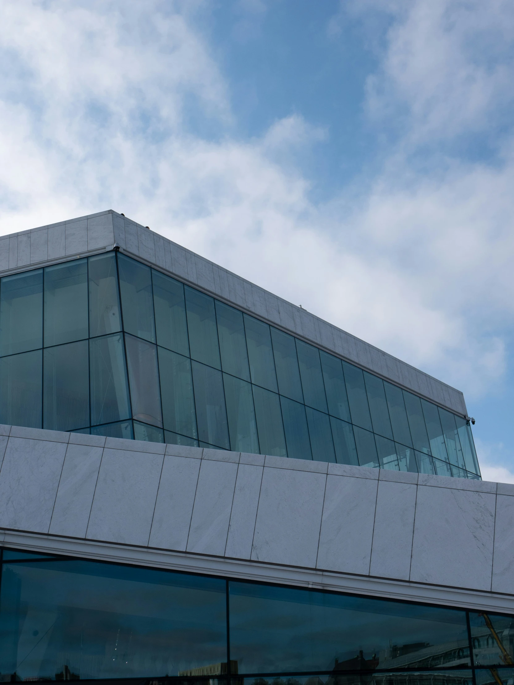 a large building sitting under a blue sky filled with clouds