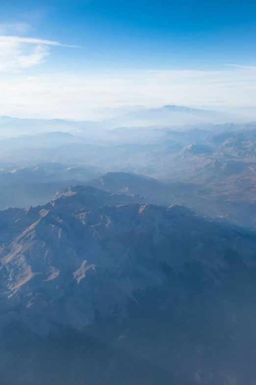 the view from the airplane shows mountains that can be seen beyond the land