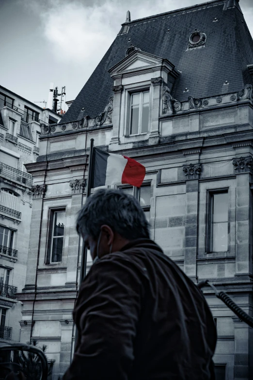 an old man in a brown coat in front of a building