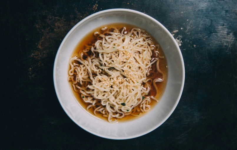 an overhead s of a bowl of noodles and sauce