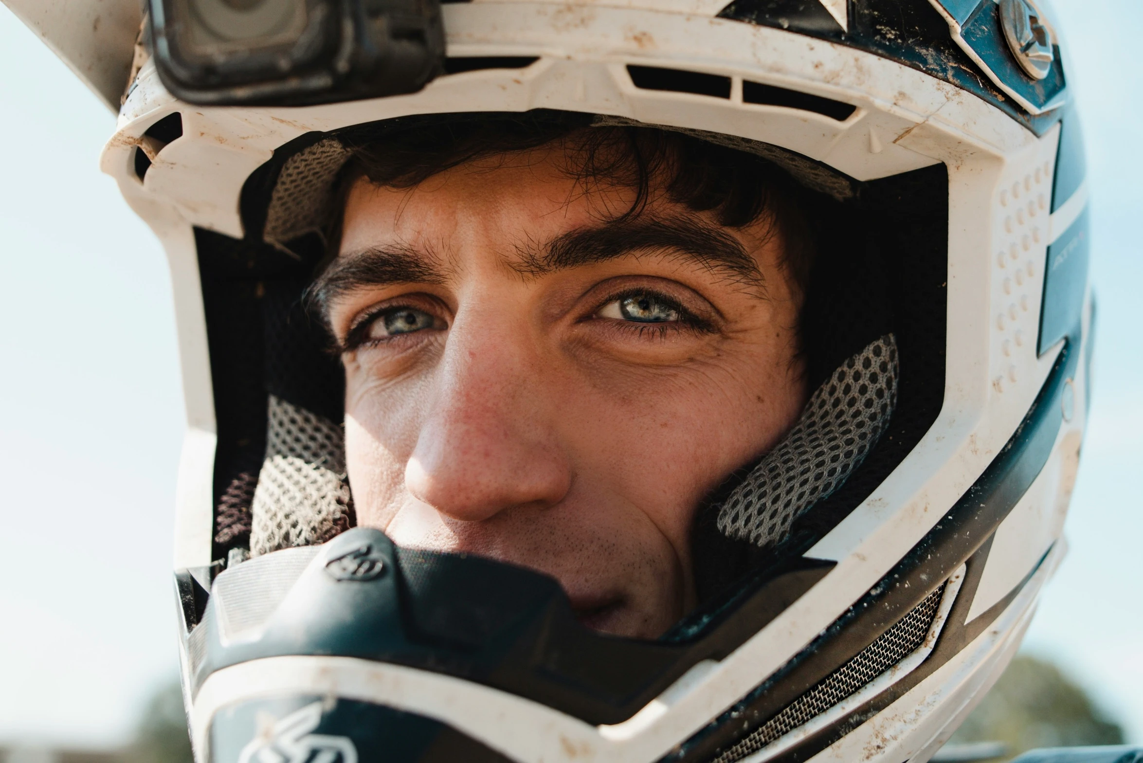 an extreme looking person in a helmet looks into the camera