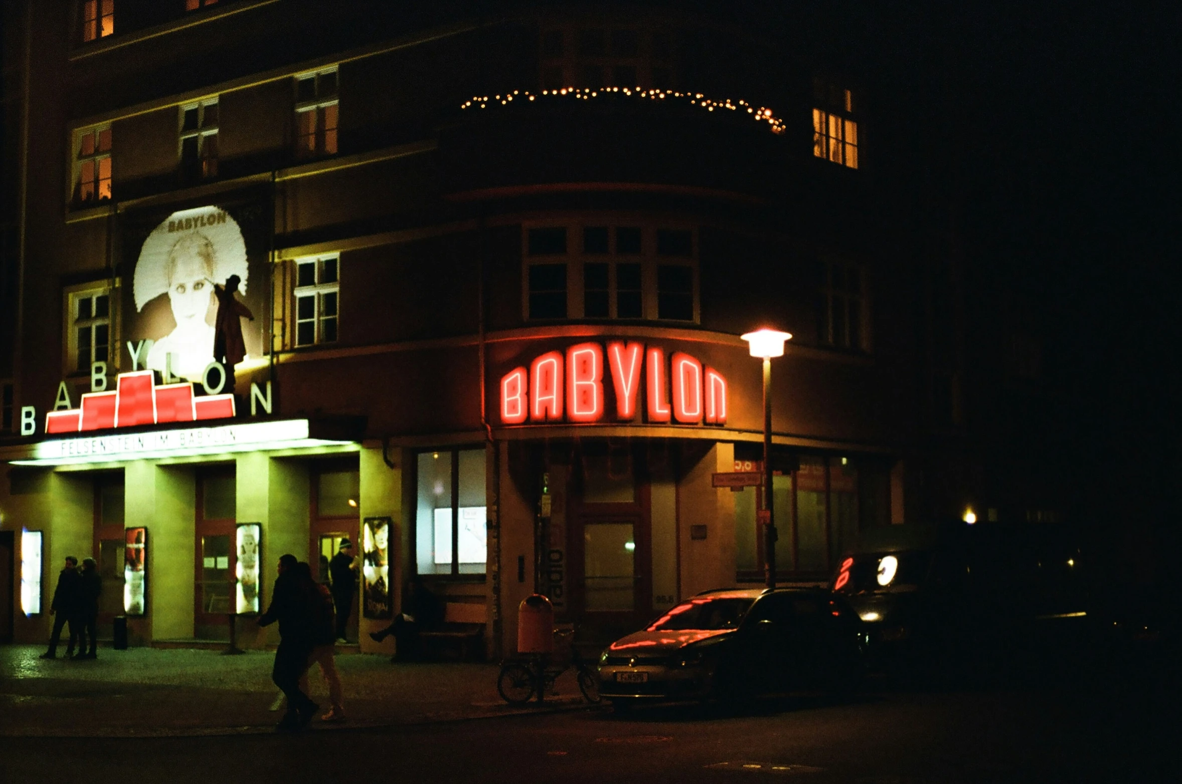 a movie theater at night on the street corner