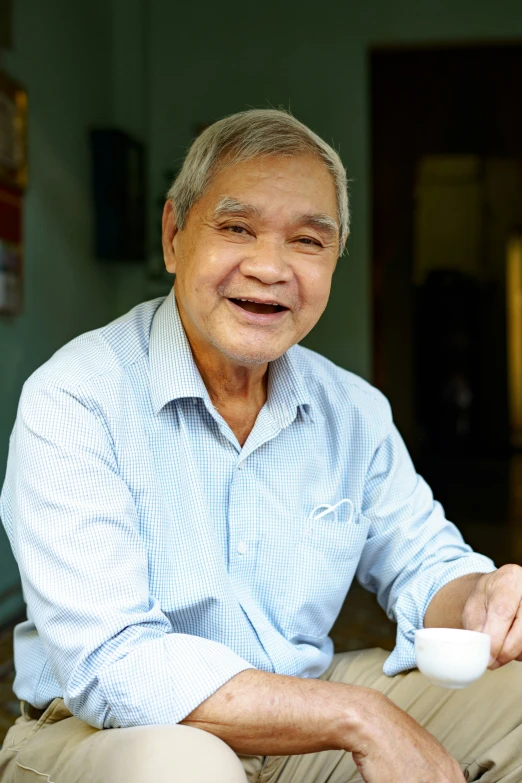 a man sits down on the ground holding a cup