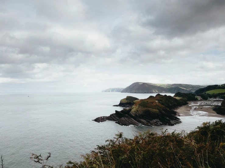 a scenic view of water, rocks and a few bushes