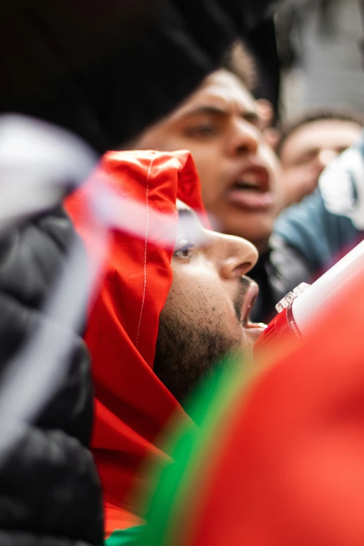 people with hoods are in the middle of a crowd