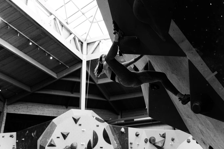 an individual is climbing a rock wall near the building