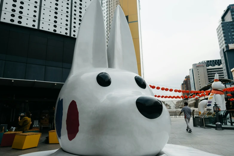 a large white dog sculpture sitting outside of a building