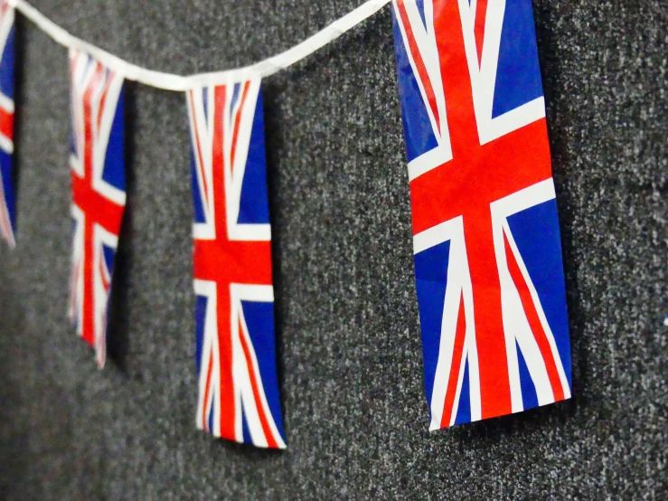 flags and bunting hanging on a gray wall