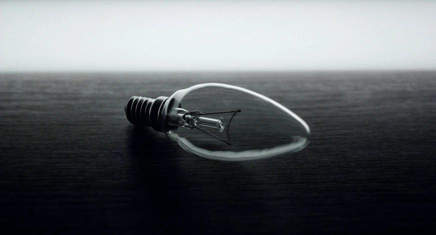 a light bulb laying on the edge of a dark surface