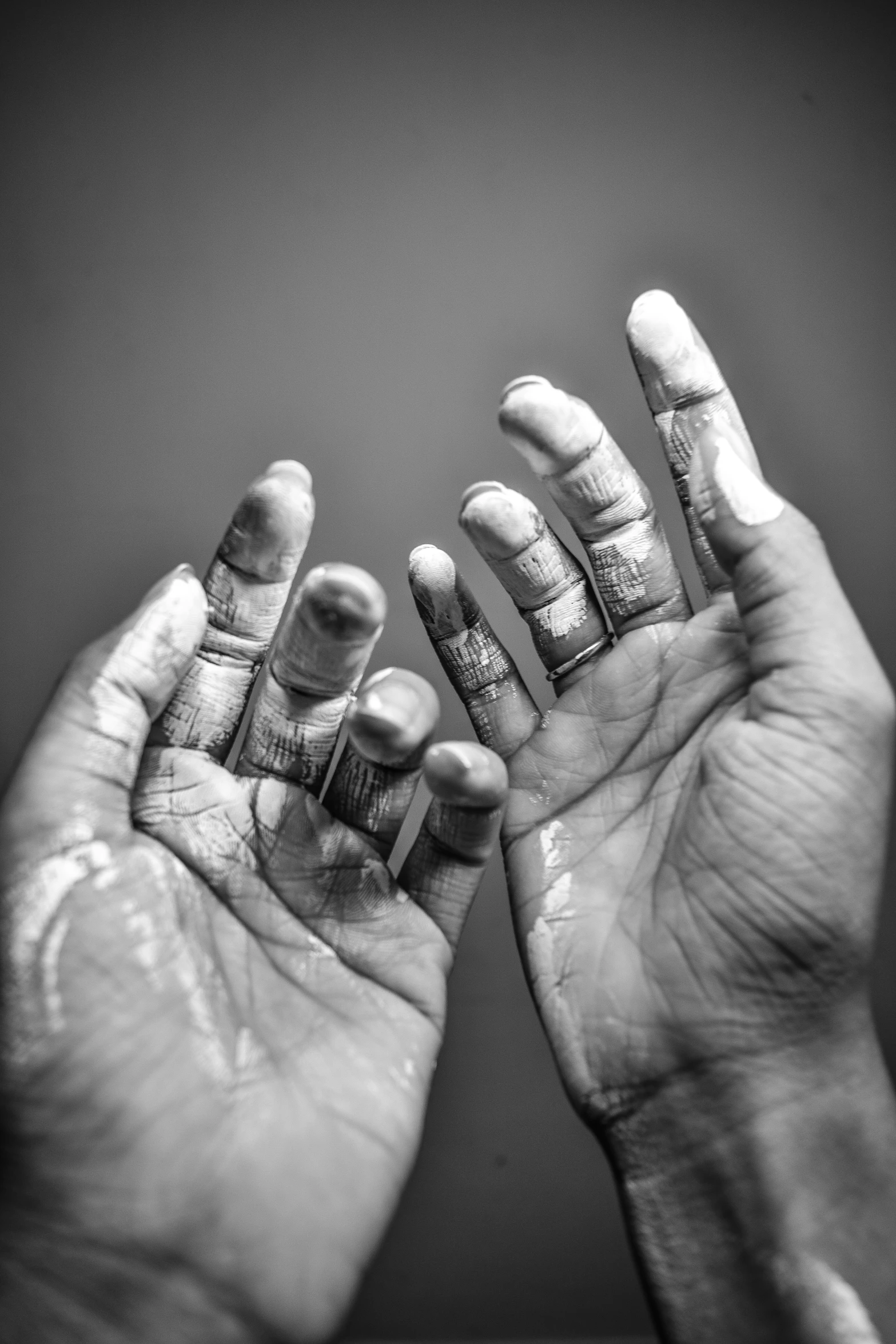 two hands covered in dirt, with one holding soing