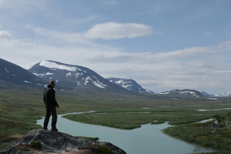 a man in a suit standing on top of a rock