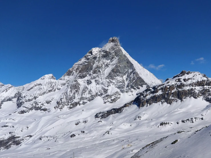 people on skis and snowboards in the snow next to mountain peak