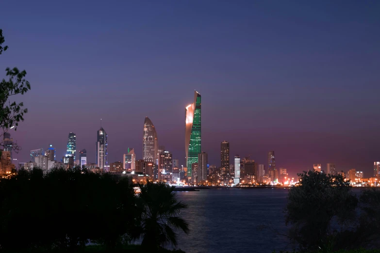 the tall building is illuminated in green at night