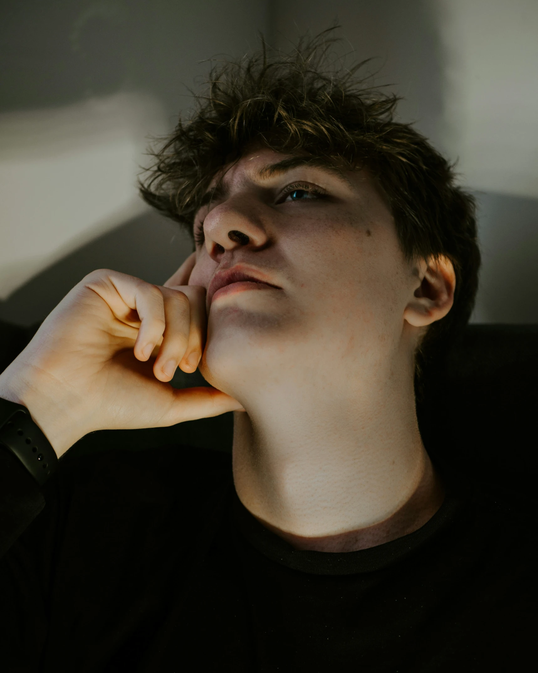 man with hair covering one side of face in dark room