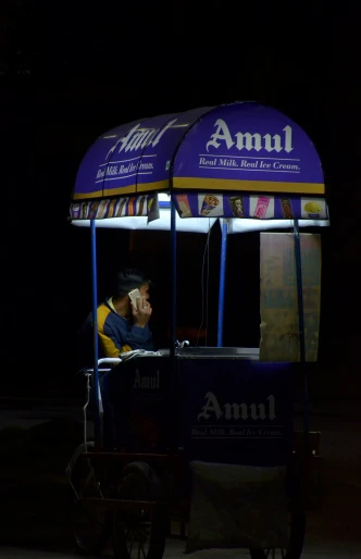 a man talks on the phone next to a small cart
